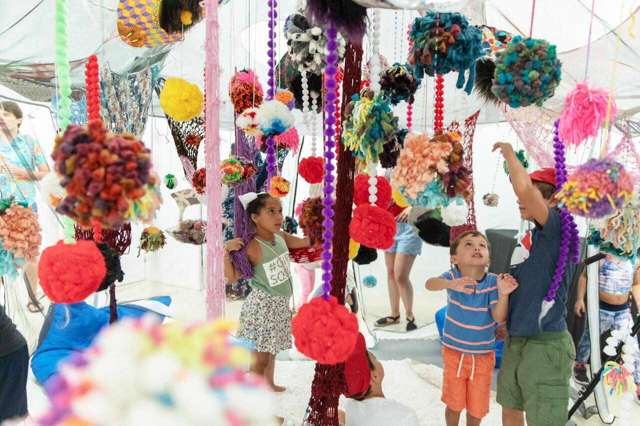 Group of children interacting with hanging art installation