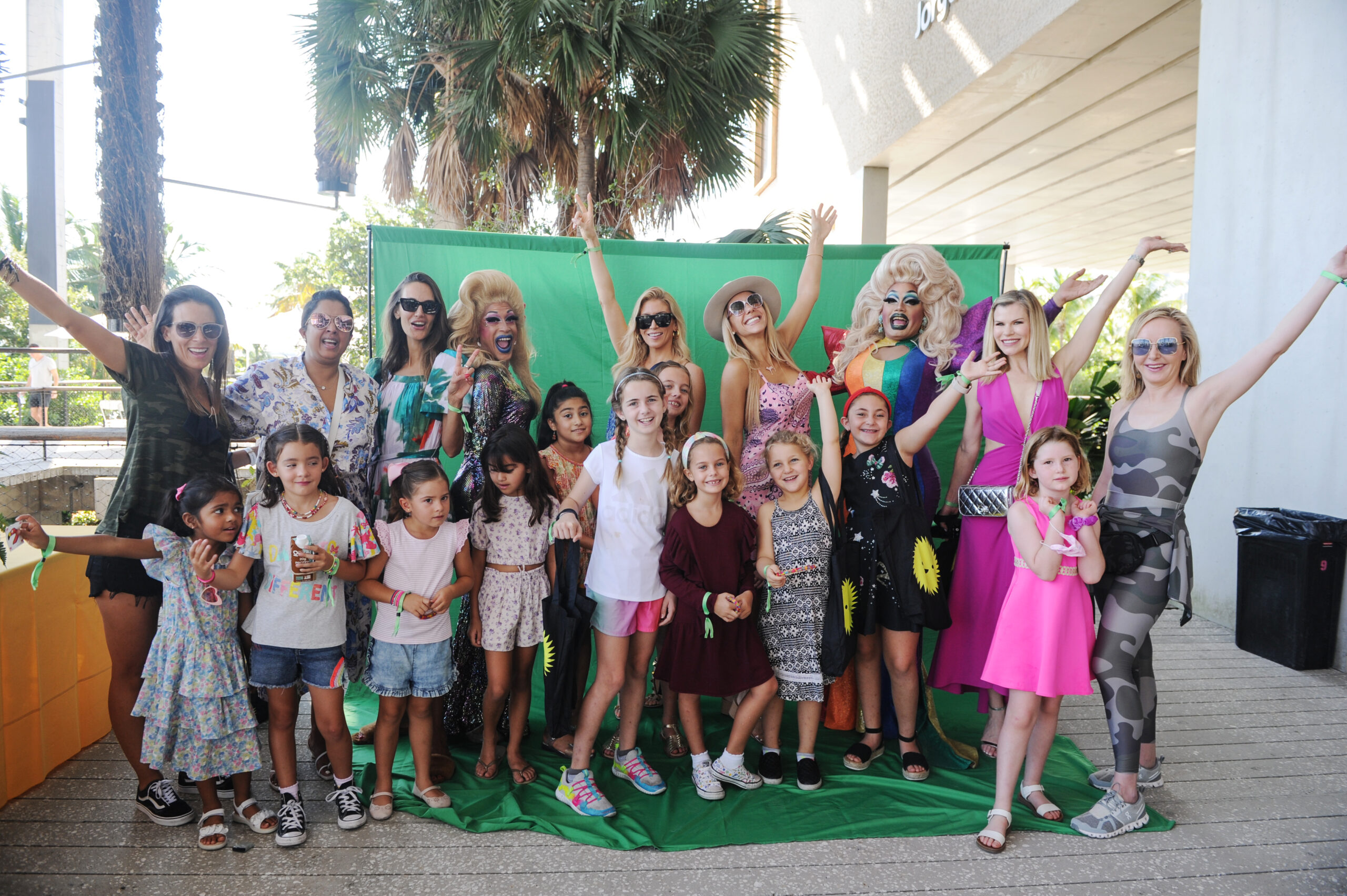 Children and adults posing in front of green screen at KIDS JAMM