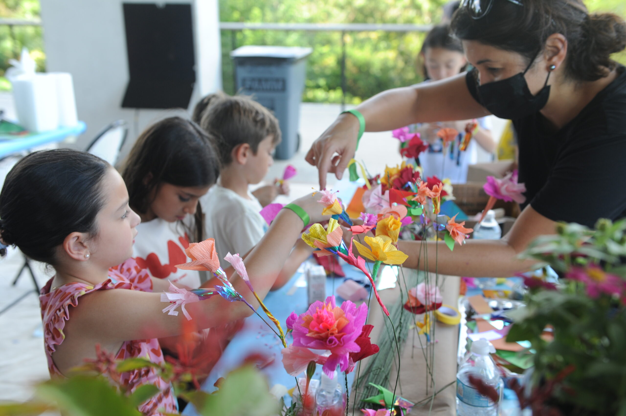 Person helps children make flower paper Mache crafts